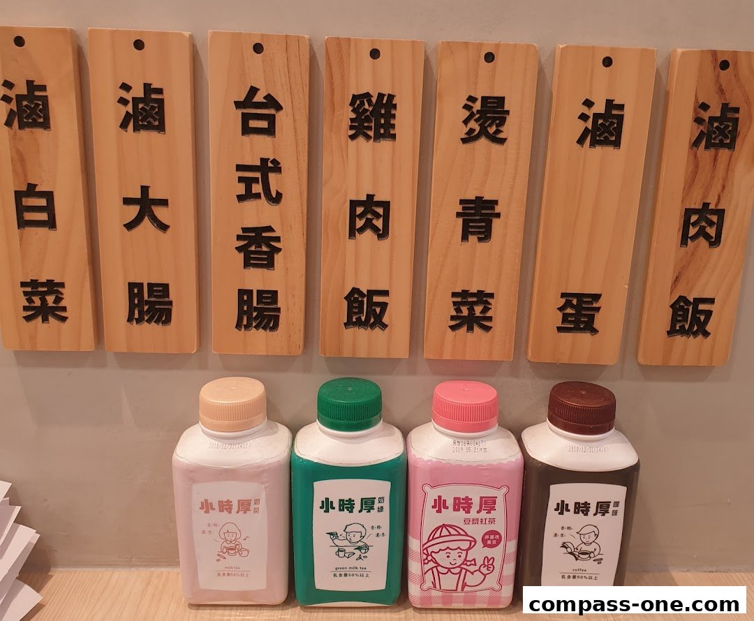 Wooden signs with Chinese characters above four bottles of drinks.