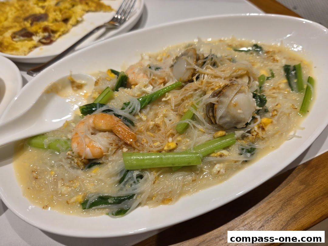 A close-up of a delicious seafood noodle dish with shrimp and scallops.