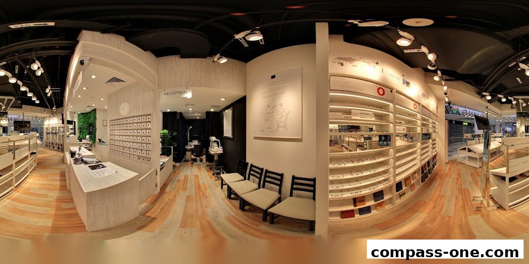 Interior view of an optical shop with displays of eyeglasses and a reception area.
