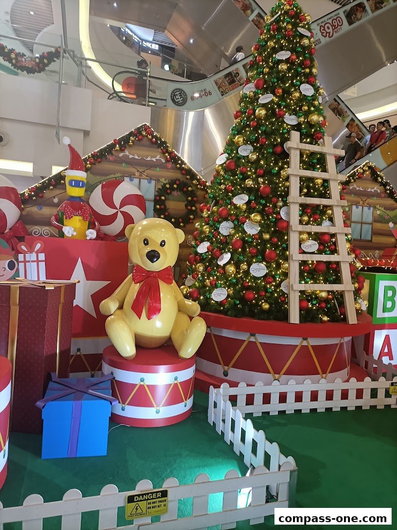 A festive Christmas display featuring a large decorated tree, gingerbread houses, and teddy bear.