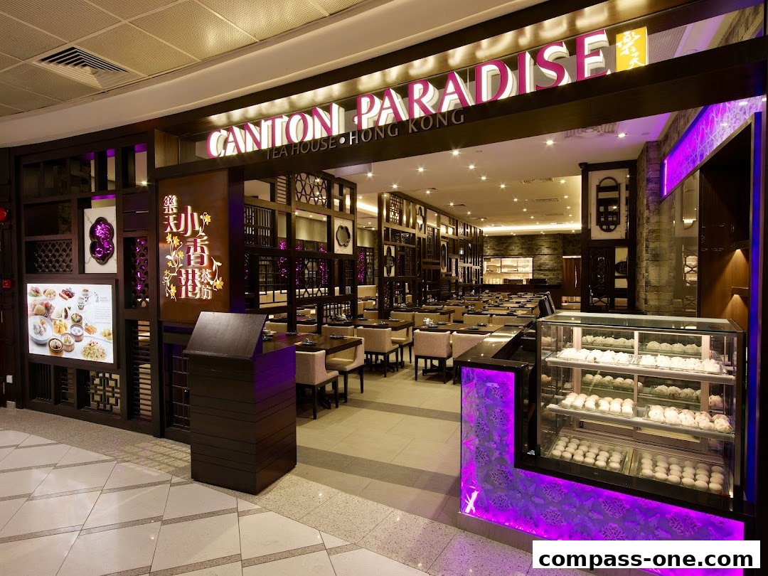 The entrance of Canton Paradise Tea House Hong Kong, featuring a display of dim sum and elegant interior seating.