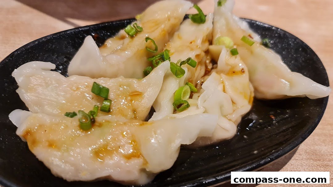 A close-up shot of delicious pan-fried dumplings garnished with chopped green onions.