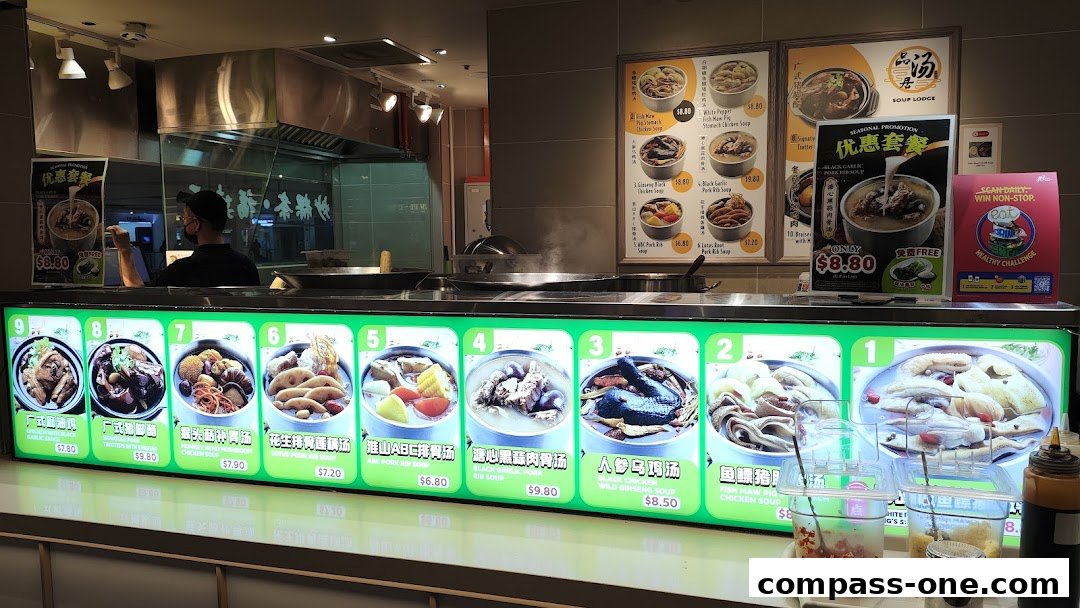 A food stall counter displaying various soup dishes with their names and prices.