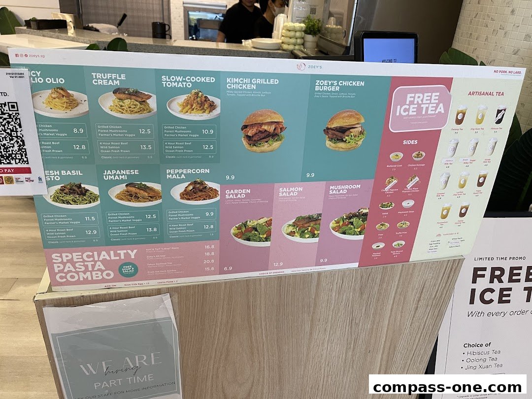 A menu board displaying various pasta dishes, burgers, salads, sides, and artisanal teas from Zoeys.