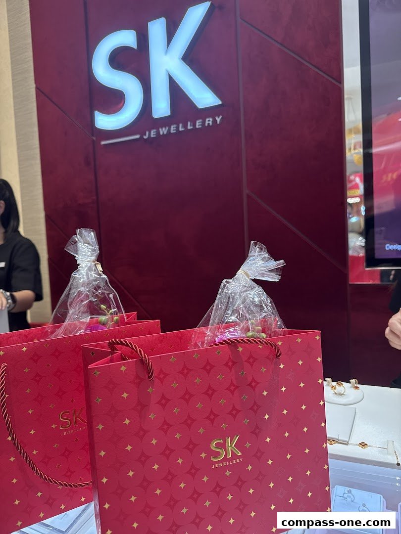 SK Jewellery shop front with red shopping bags and illuminated logo.