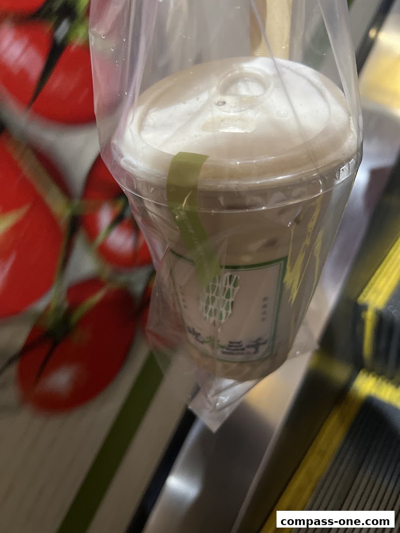 A close-up of a bubble tea drink in a plastic bag, with a logo on the cup.