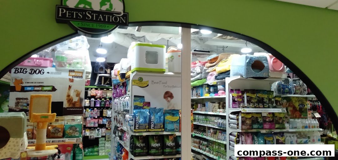 The entrance of a pet store, Pets Station, showcasing various pet food and accessories.