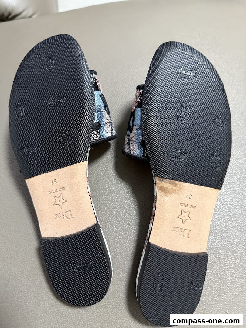 Close-up view of the soles of two designer sandals with butterfly patterns.