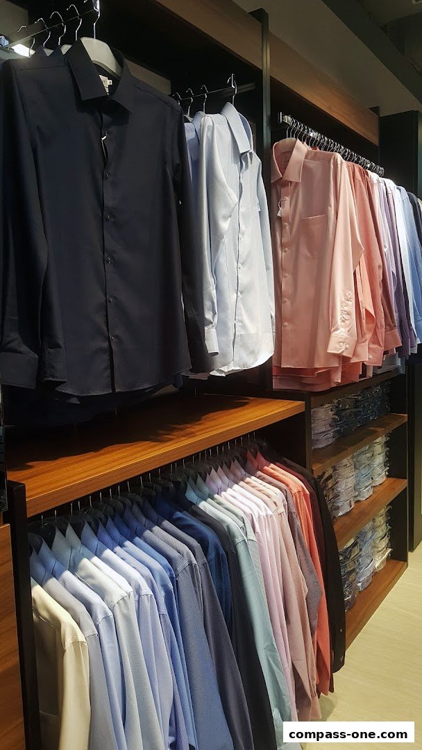 A display of neatly hung men's dress shirts in various colors and styles.