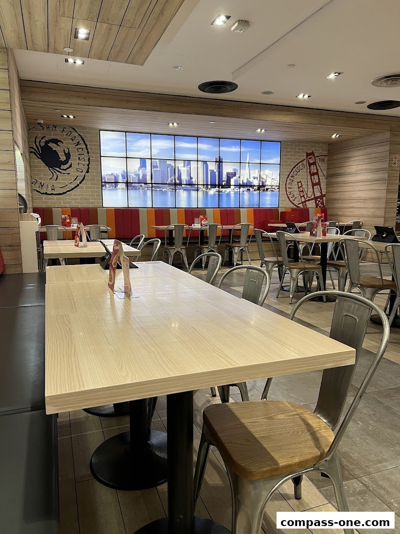 Interior view of a Swensen's restaurant with tables, chairs, and a large screen displaying a San Francisco cityscape.