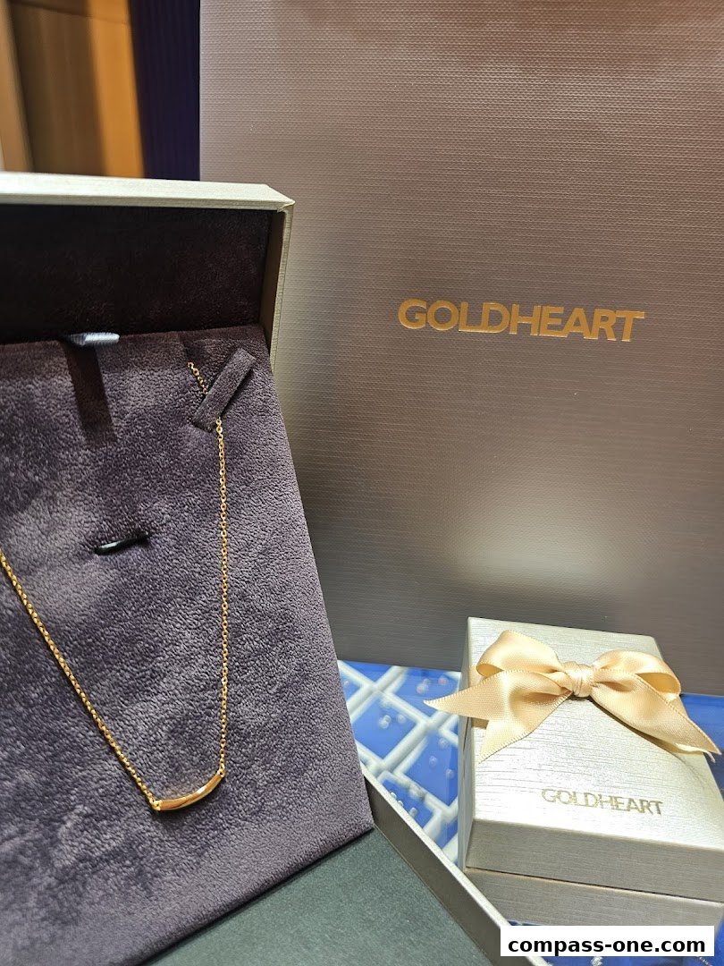 A gold necklace displayed in a jewelry box with Goldheart branding.