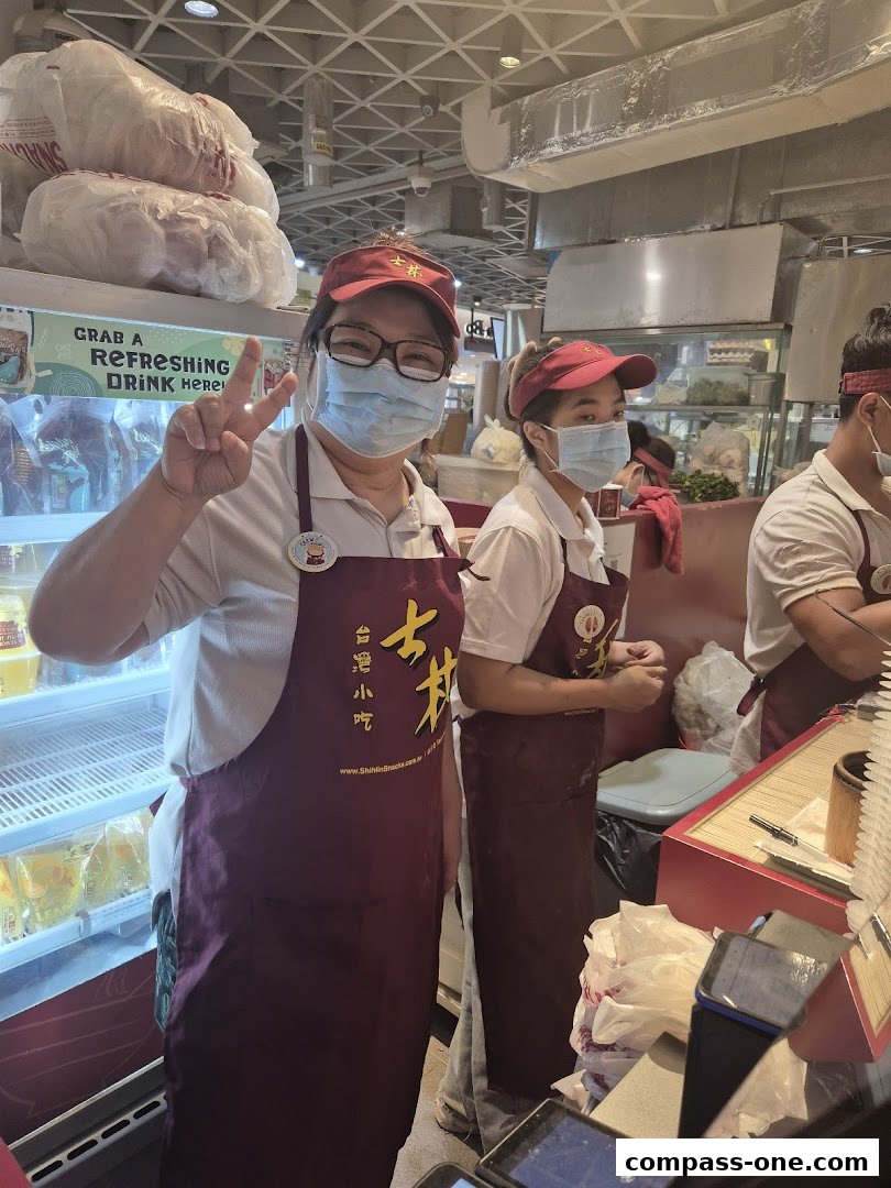 Staff at Shihlin Taiwan Street Snacks posing for a photo with a peace sign.