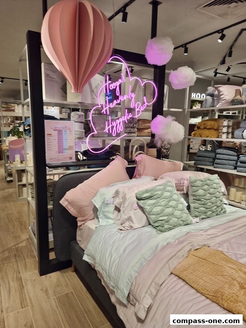 A bed display with soft pastel bedding and decorative clouds and a hot air balloon.