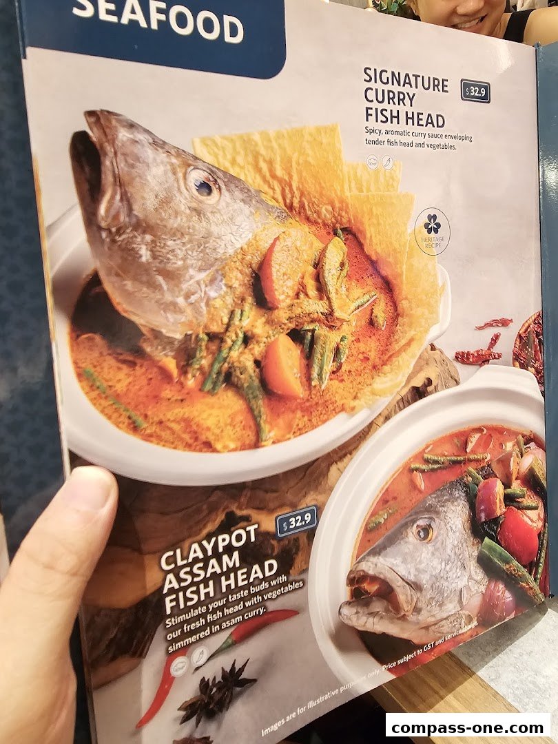 A menu featuring two fish head dishes: Signature Curry Fish Head and Claypot Assam Fish Head.
