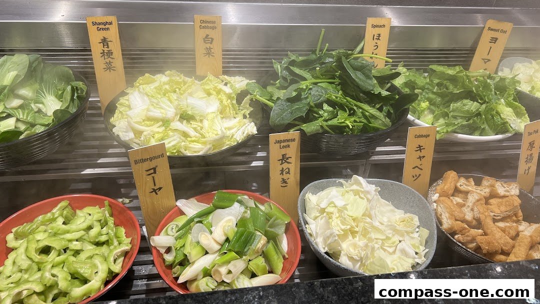 A variety of fresh vegetables and fried tofu are displayed for a hot pot meal.