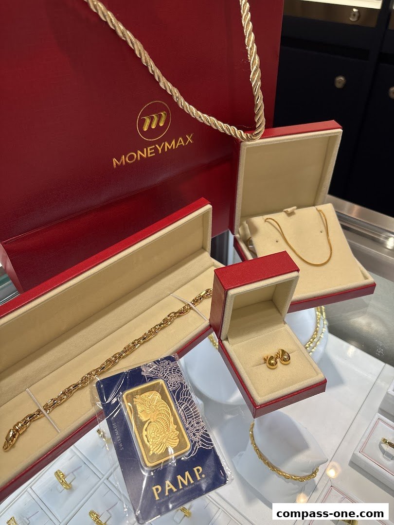 A display of gold jewelry including a bracelet, earrings, necklace, and a PAMP gold bar.