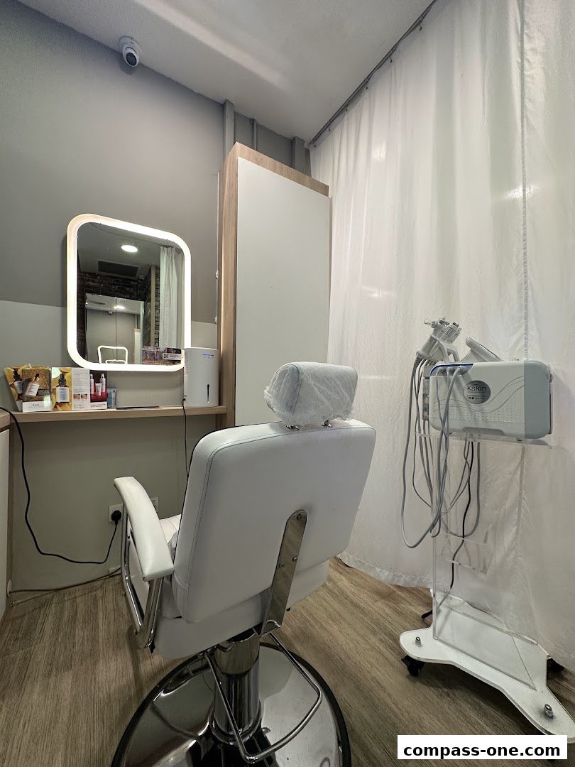 A clean and modern facial treatment room with a white chair and beauty equipment.