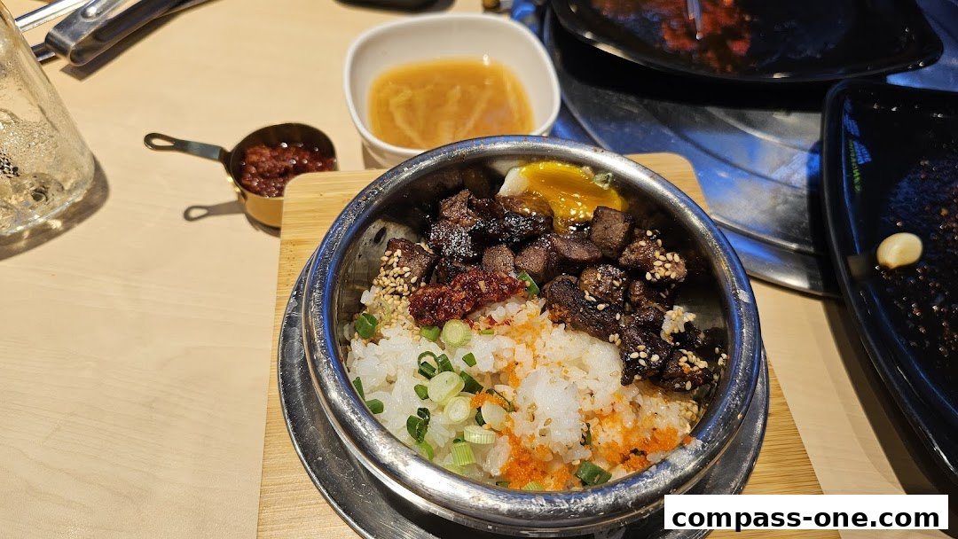 A close-up of a Korean bibimbap dish with beef, rice, egg, and toppings.