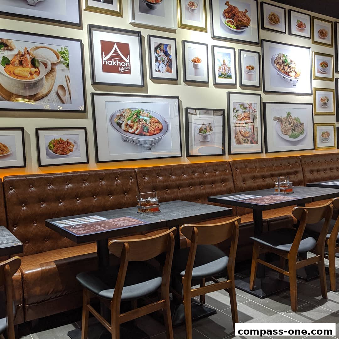 Interior of Nakhon Kitchen with framed food pictures and seating.