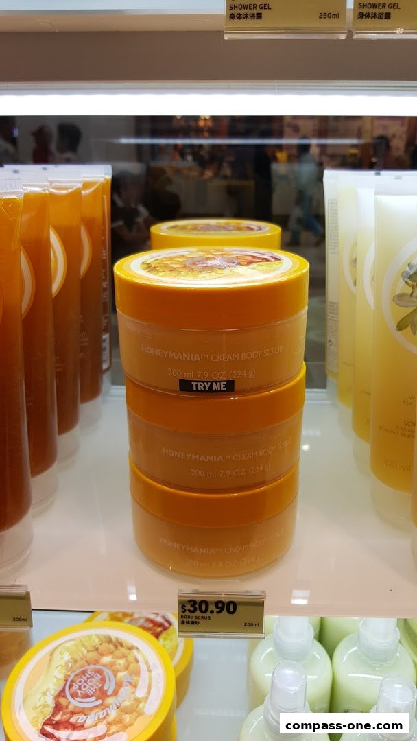 The Body Shop display featuring Honeymania Cream Body Scrub and Shower Gel.
