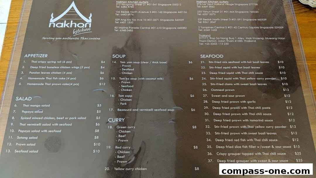 A menu from Nakhon Kitchen featuring Thai cuisine, including appetizers, salads, soups, curries, and seafood dishes.