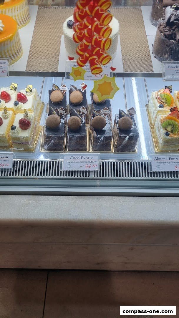 A display case filled with various beautifully decorated cakes and pastries.