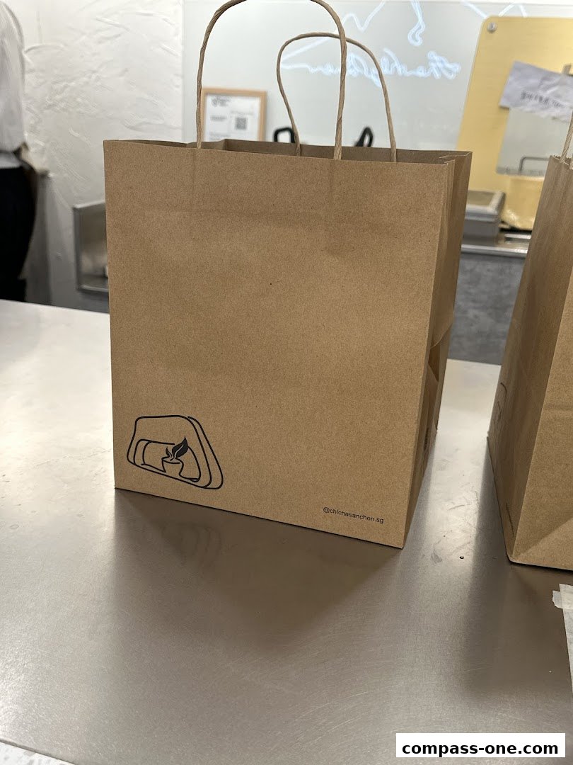 Brown paper shopping bags with the CHICHA San Chen logo and social media handle.