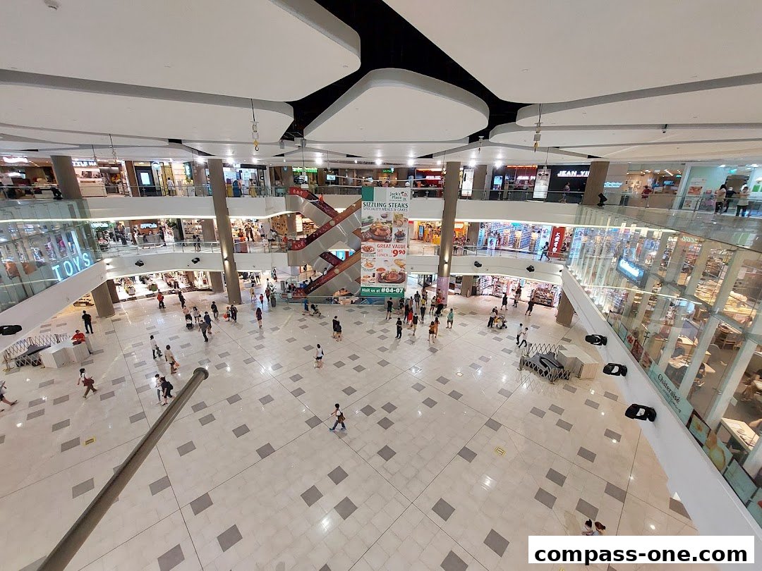 A wide-angle view of a bustling shopping mall interior with multiple levels and shops.