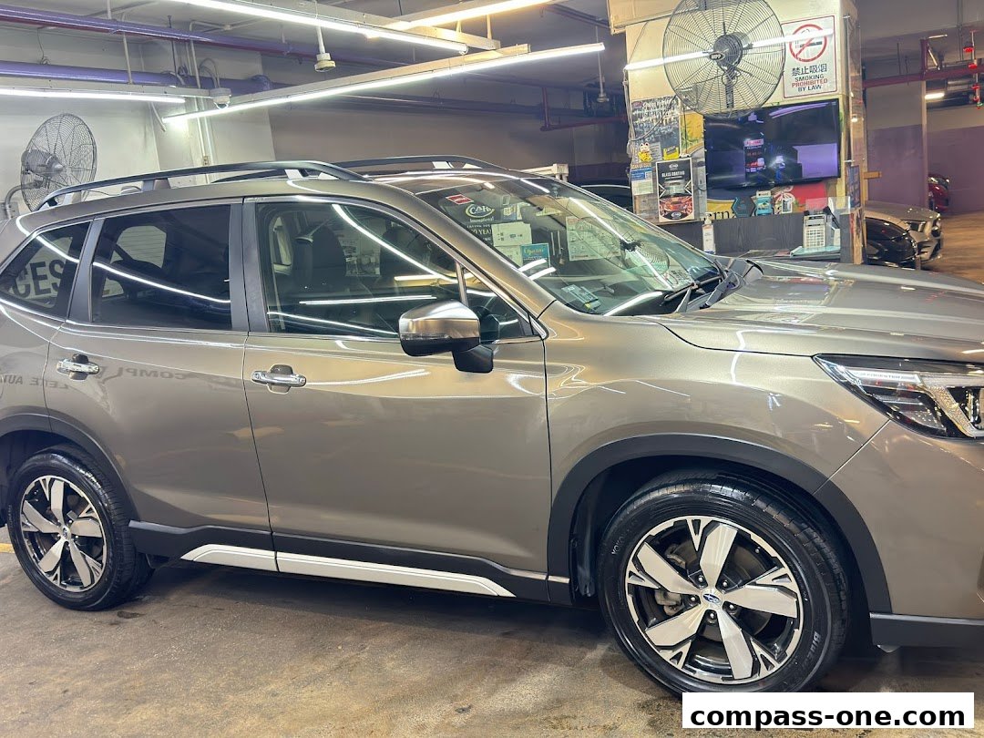 A close-up of a clean, brown SUV parked indoors, likely at a car detailing service.