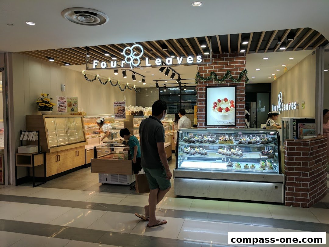A bakery shop called Four Leaves with display cases full of cakes and pastries.
