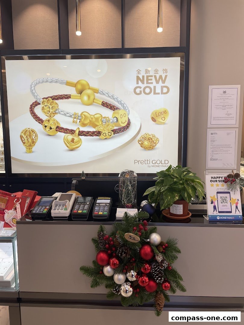 A display counter at MoneyMax featuring new gold jewelry and payment terminals, decorated for Christmas.