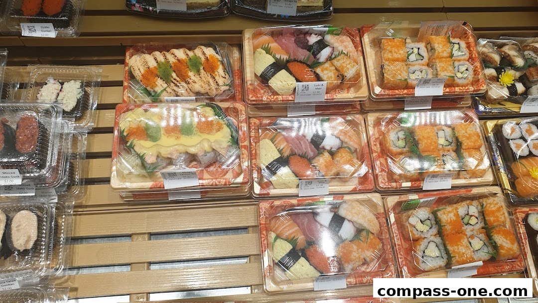 A variety of pre-packaged sushi and rolls displayed in clear plastic containers.