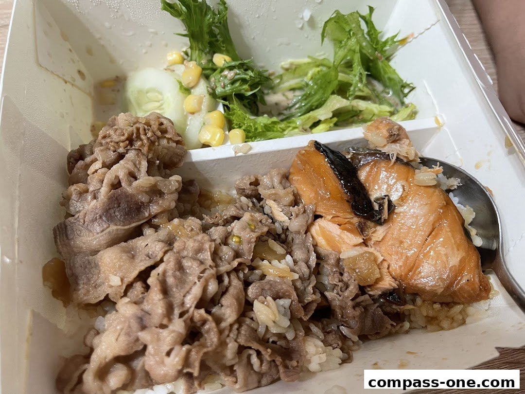 A bento box with rice, beef, salmon, and a side salad.