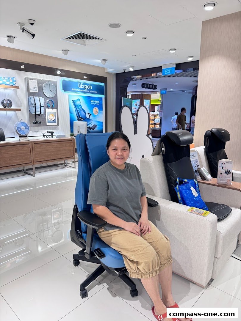 A woman sits in a blue massage chair in a well-lit retail store with other massage chairs.