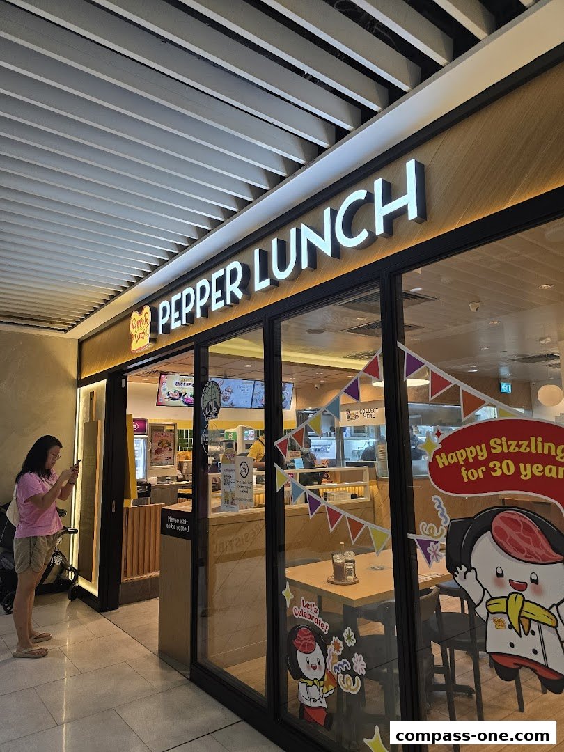 The exterior of a Pepper Lunch restaurant with its prominent signage and a customer taking a photo.