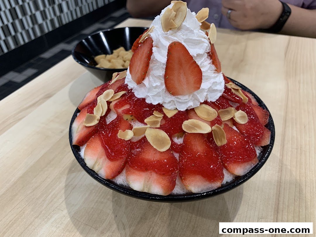 A close-up of a strawberry shaved ice dessert topped with whipped cream and almonds.