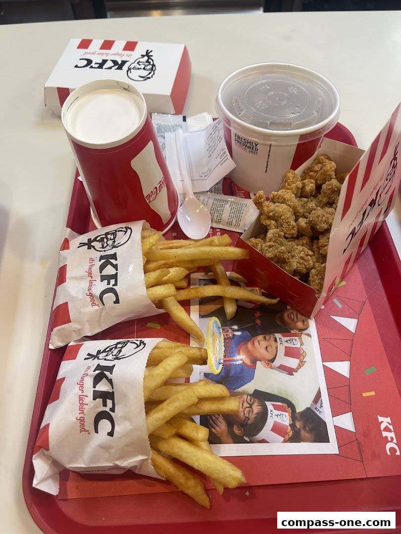 A tray of KFC food including chicken, fries, drinks, and a burger box.
