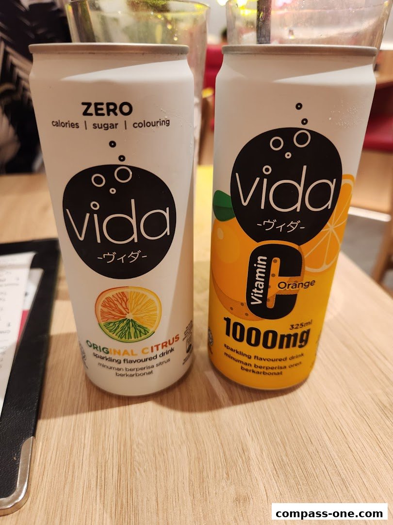 Two cans of Vida sparkling flavored drinks, one Original Citrus and one Vitamin C Orange.