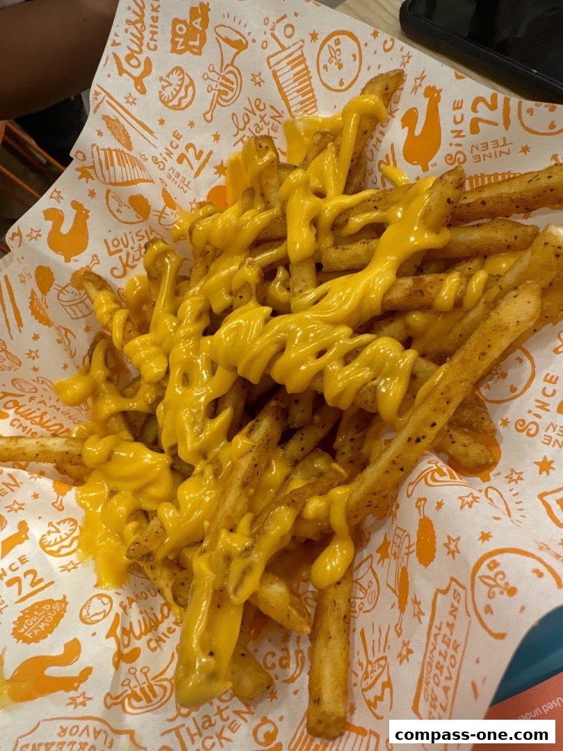 A close-up shot of Popeyes' famous cheese fries, generously topped with melted cheese.