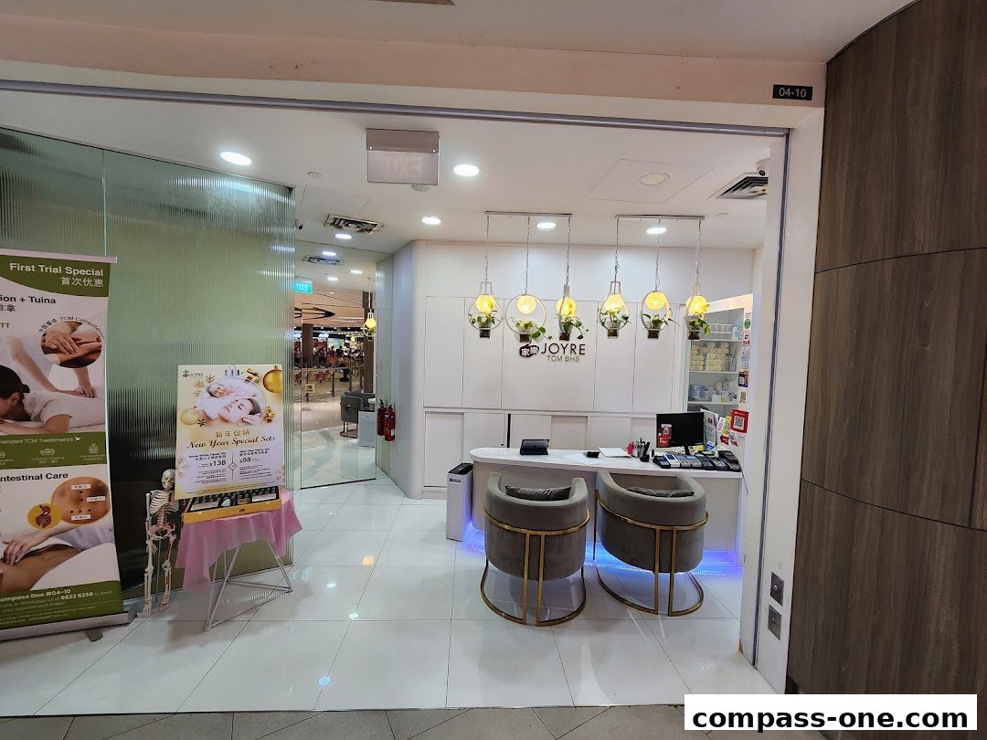 The entrance of Joyre TCMedi Spa, featuring a reception desk, seating, and promotional posters.
