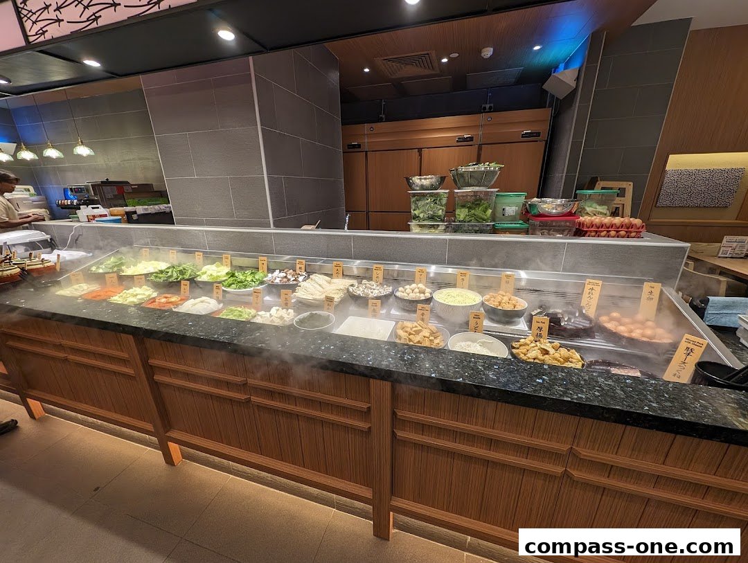 A display of fresh ingredients for hot pot, including vegetables, meats, and seafood.