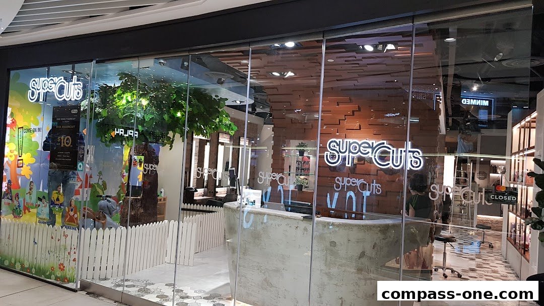 The exterior of a Supercuts hair salon with a bright, modern interior visible through the glass.