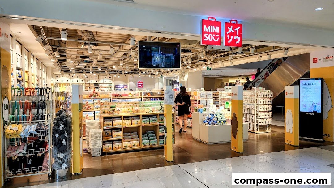 The entrance of a MINISO store filled with various merchandise, including umbrellas, plush toys, and stationery.