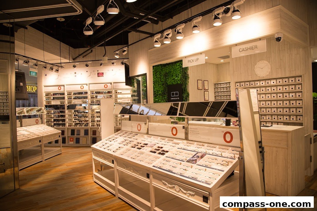 Interior of an optical shop with displays of eyeglasses and a cashier counter.