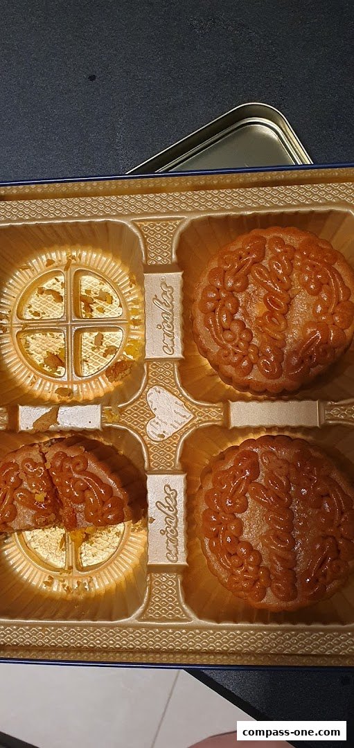 A box of Emicakes mooncakes, with one mooncake cut in half.