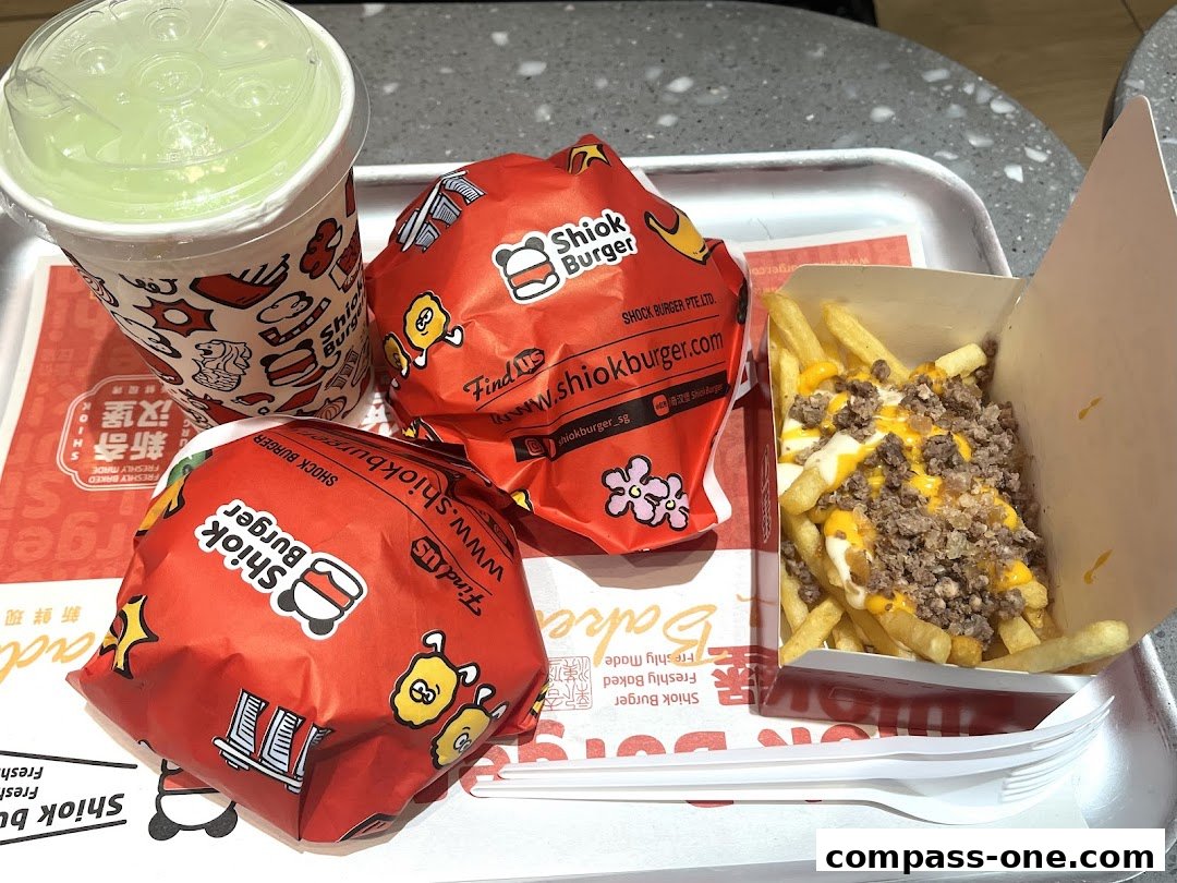 A tray with two burgers, a drink, and loaded fries from Shiok Burger.