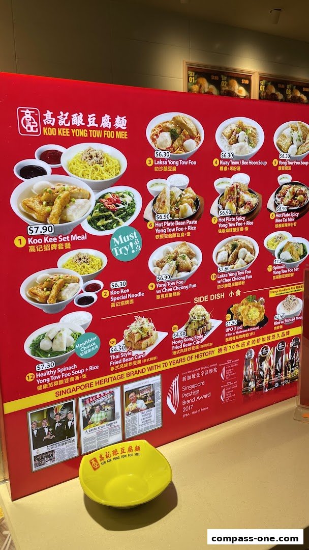A vibrant menu display for Koo Kee Yong Tow Foo Mee, showcasing various noodle dishes and side items.