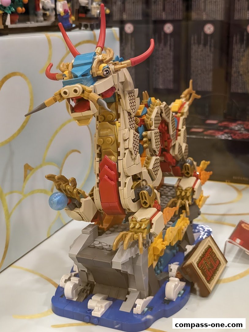 A detailed LEGO model of a mythical dragon on a rocky base with water elements.