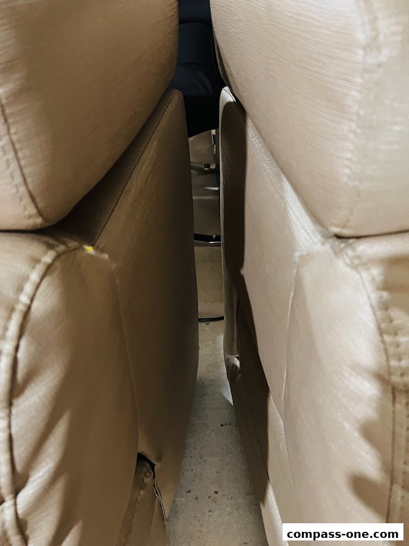 Close-up view of two beige upholstered chairs, showing the gap between them.