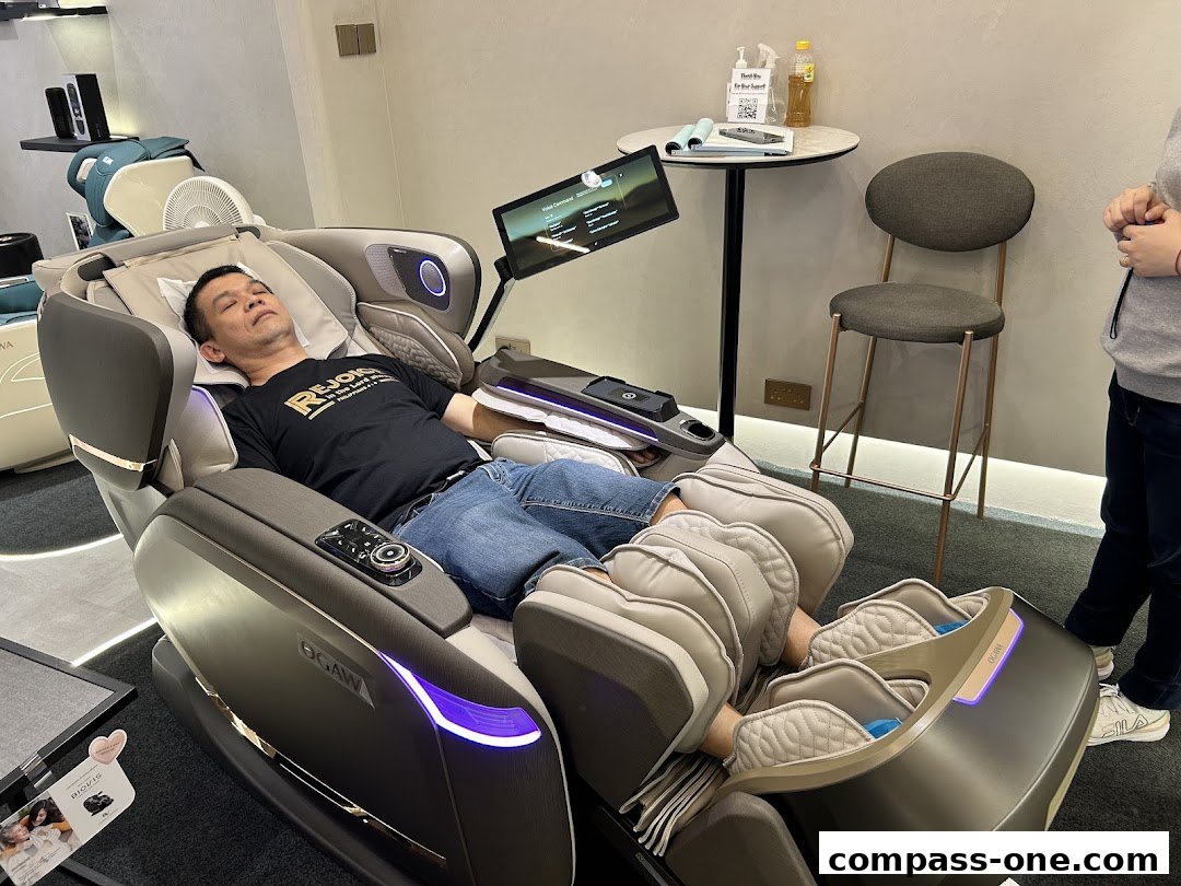 A man relaxes in a high-tech massage chair with a screen displaying massage options.